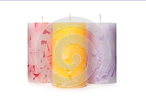 Three color wax candles on white