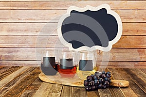 Three color wine flight in chalkboard glasses with a sign