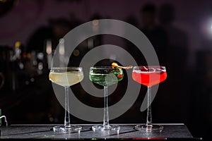 Three colored cocktails on the bar.