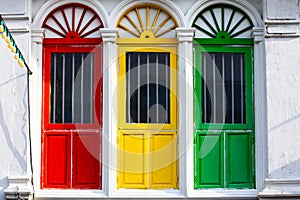 Three colored doors or windows outside on the facade of an ancient house photo