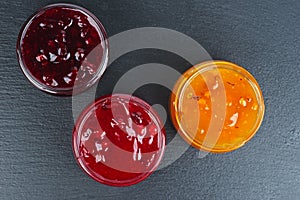 Three colored jam in glass jare isolated on a black background