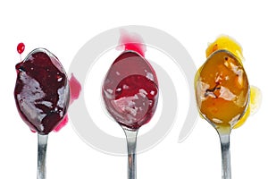 Three colored jam on a spoon isolated on a white background