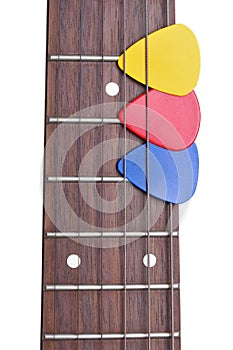 Three colored mediators on a guitar fretboard