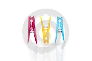 Three colored plastic clothes pegs side by side