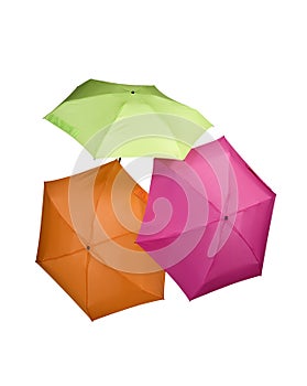 three colored umbrellas green pink orange color isolated on white background