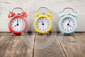 Three colorful alarm clocks