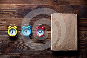 Three colorful alarm clocks and book