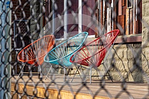 Three colorful garden chairs on a verandah