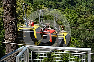 Three colorful gondolas cable cars as they transport people up and down in the Caracol Park