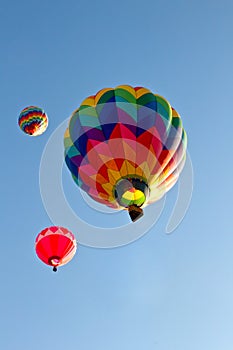 Three colorful hot air balloons ascending into sky