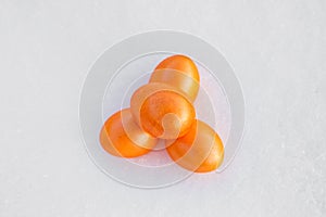 Three Colorful orange Easter eggs on white snow