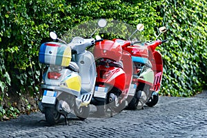 Three colorful scooters at the street, Rome, Italia