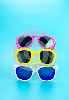 Three colorful sunglasses at light blue studio background,Summer Holiday concept