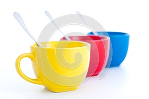 Three colorful tea cups with spoons