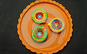 Three colorful terracotta oil lamp or diya in Earthenware on blue cloth background