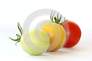 Three colorful tomatoes on white background