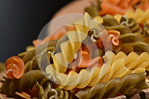 Three Colors Rotini Pasta. Twisted colored pasta in Italy. On a black background