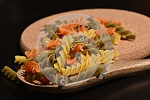 Three Colors Rotini Pasta. Twisted colored pasta in Italy. On a black background