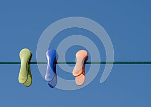 Three coloured cloths pegs in line