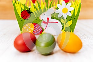 Three colourful blurred Easter eggs in front of decorative felt basket