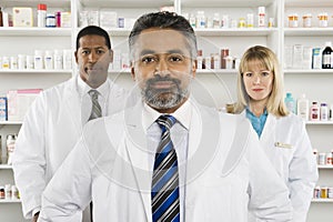 Three Confident Pharmacists Standing At Pharmacy