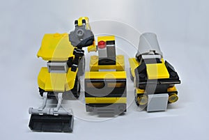 Three construction heavy machine toys made from plastic blocks