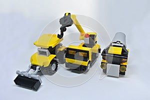 Three construction heavy machine toys made from plastic blocks