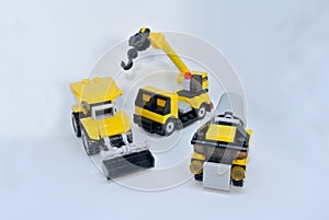 Three construction heavy machine toys made from plastic blocks