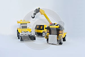 Three construction heavy machine toys made from plastic blocks