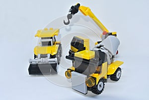 Three construction heavy machine toys made from plastic blocks