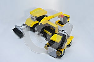 Three construction heavy machine toys made from plastic blocks