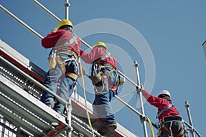 Construction workers in safety gear installing scaffolding