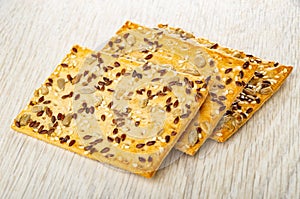 Three cookies with sunflower seeds, flaxseeds and sesame on table