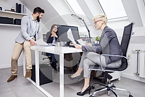 Three cooworkers with plans on table