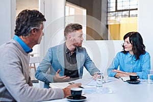 Three coworkers having a strategy meeting in a modern office