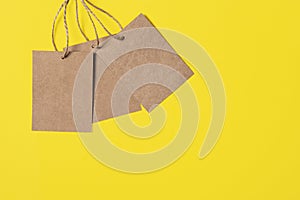Three Craft brown paper tags isolated on bright yellow background. Sale or price banner with copy space in minimal style