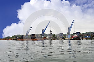 Three crane unloading coal from barge to hopper