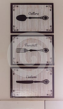 three cream and black paintings with drawings of a fork, knife and spoon photo