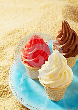 Three cripsy wafer cones with ice cream on sand
