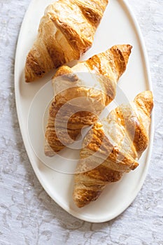 Three croissants on plate.