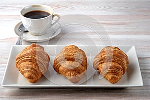 Three croissants on a rectangular plate.