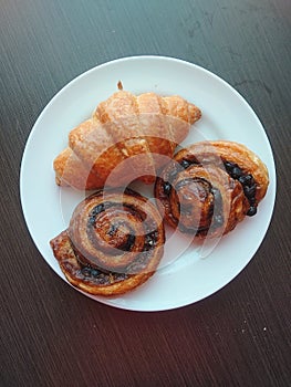 Three croissants on white plate