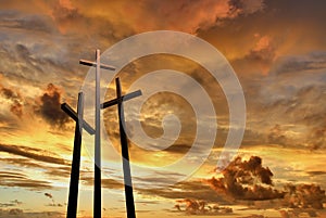 Three crosses on a hill over bright sunset