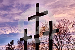 Three crosses in silhouette at sunset, dramatic sky