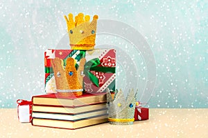 Three crowns of the three wise men with books,christmas gift boxes and snowflakes