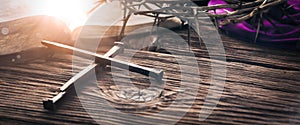 Three Crucifixion Spikes In Shape Of Cross On Wooden Table With Bible, Crown Of Thorns And Purple Robe