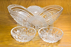 Three crystal vases for sweets on a wooden surface