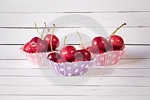 Three cupcake liners with cherries