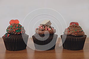 Three cupcakes with difference toppings on table