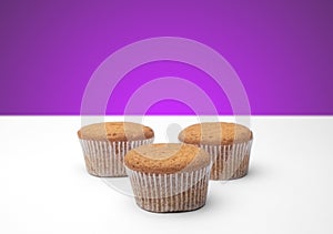 Three cupcakes on a wooden table